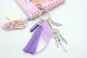 Detailed view of bohemian dreamcatcher keychain with purple tassels and turquoise stone