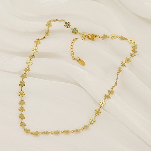 Collana vintage a fiori dorati con smalto blu centrale su sfondo di seta bianca