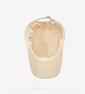 Detail of adjustable metal buckle and inner cotton stitching on beige baseball cap