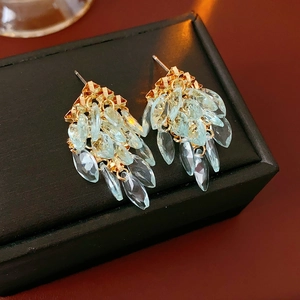 Gros plan de boucles d'oreilles géométriques à pampilles avec cristaux bleu clair