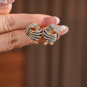 Détail de boucles d'oreilles ailes vintage dorées avec cristaux et émail noir élégant