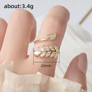 Detail showing an adjustable gold leaf ring with sparkling zircons worn on a finger