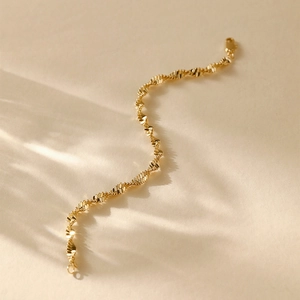 Detail of 14K gold plated bracelet featuring a modern spiral twisted chain design