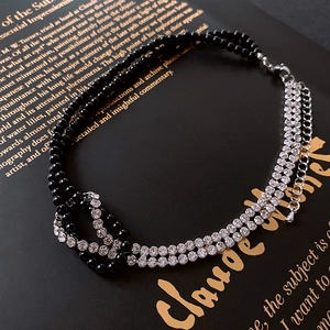 Close-up of double-layered choker with black beads and sparkling rhinestone knots