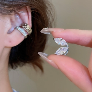 Gros plan d'un clip d'oreille en argent avec zircons en forme de feuille sur l'oreille