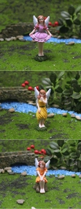 Tre miniature di fate con abiti colorati e ali traslucide in una scena di giardino