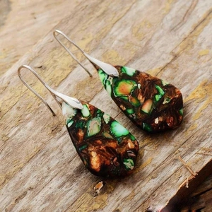 Bohemian teardrop earrings with colorful imperial stone and silver hooks on wood background