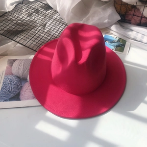 Detailed close-up of rose red wool felt fedora with stylish wide brim and jazz style