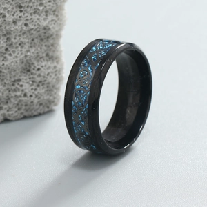 Detailed macro view of black stainless steel ring featuring blue dragon inlay pattern