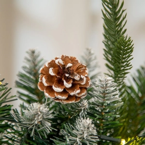 Macro shot of 9ft Christmas garland featuring snow-tipped pine cones and frosted needles