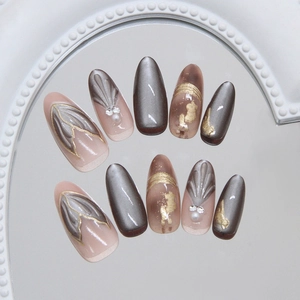 Cat eye press-on nails with 3D shell texture, gold leaf edges and pearl accents