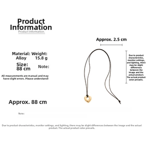 Detail view of a 2.5cm gold heart pendant on an 88cm black cord long necklace