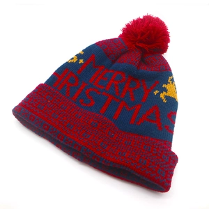 Detailed close-up of knitted Merry Christmas pattern and reindeer on a winter beanie hat