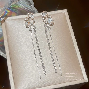 Macro shot of silver heart tassel earrings with sparkling zircon stones on jewelry box