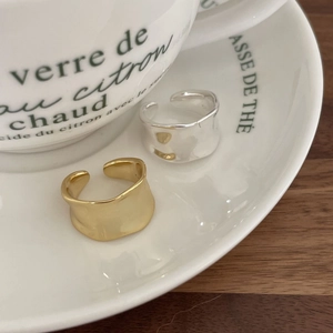 Close-up of wavy irregular 925 silver rings with hammered texture in gold and silver