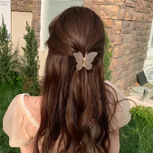 Elegant frosted butterfly hair claw clip in beige on brown wavy hair for women