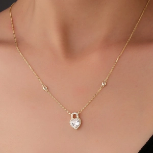 Elegant gold S925 silver heart lock necklace with pavé zircon stones on a female neck