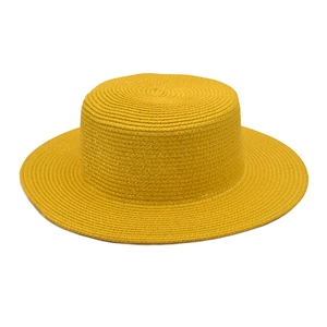 Close-up of bright yellow straw boater hat with a dense woven texture and flat top