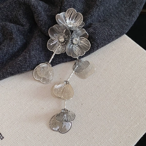 Detail of silver hollow flower earrings with rhinestones and long tassel fringe