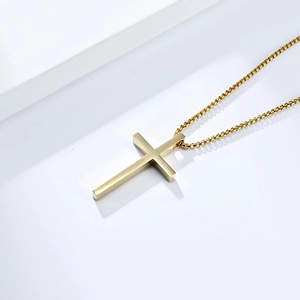 Close-up of a gold minimalist cross pendant necklace with matching box chain