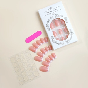 Close-up of French tip press-on nail kit with adhesive tabs and pink nail file tool