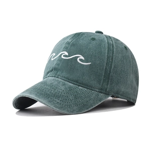 Detailed close-up of white wave embroidery on washed cotton deep teal baseball cap