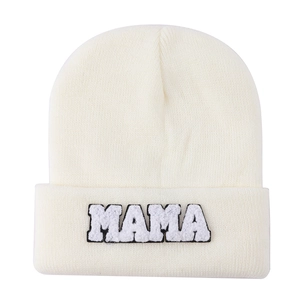 Detailed view of MAMA towel embroidery and soft knit texture on cream white beanie
