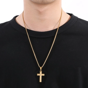 Gold stainless steel cross necklace with crystal pavé worn by a model on a box chain