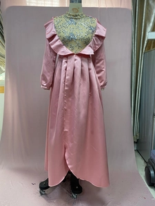 Detail of pink satin evening gown featuring sequin floral embroidery and ruffled neckline