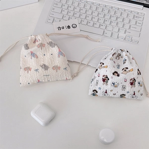 Close-up of cute cartoon drawstring pouches with textured fabric for makeup and accessories