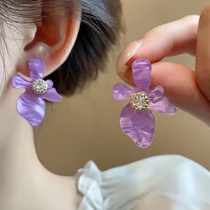 Orecchini a lobo a fiore in resina viola con zircone centrale e montatura dorata