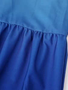 Macro du tissu à dégradé bleu montrant la texture plissée et les détails de couture