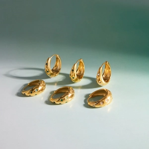 Trois paires de boucles d'oreilles créoles dorées ornées de pierres gemmes en étoile