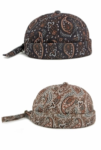 Détail de bonnets docker paisley bleu et beige avec sangles réglables et texture canevas