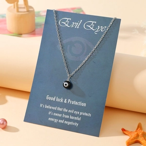 Detail of evil eye amulet necklace with black bead pendant on English backing card