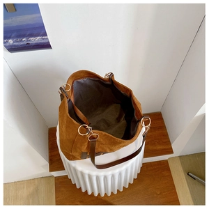 Top view of spacious brown suede tote bag with leather straps and gold hardware