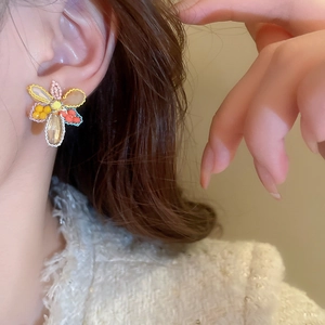Boucles d'oreilles fleurs en perles de cristal colorées portées par un mannequin