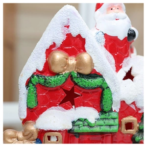 Detailed macro view of a ceramic Christmas house ornament with snow-capped roof and star cutout