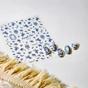 Blue bow and floral patterns on white nail stickers with French Chic pearl decorations