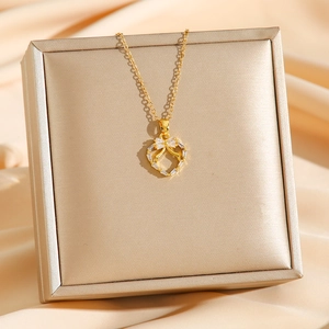 Collier en acier titane doré avec pendentif cœur et nœud serti de zircons brillants