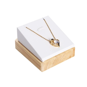 Golden heart necklace with large center diamond on wood and leather display stand