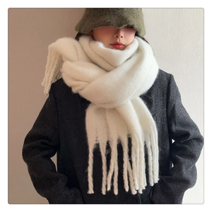 Detailed close-up of thick white mohair scarf with soft texture and long tassels