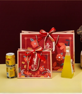 Detail of red festive gift bags showing size capacity comparison with bottled drinks