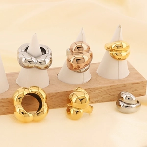 Detailed close-up of chunky polished 18k gold and silver geometric rings on display