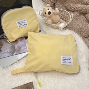 Detail of light yellow waterproof travel organizer bags with soft zippers on a cozy background