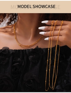Detailed view of layered gold bead chain necklace showcased on a model neck