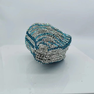 Close-up of luxury shell clutch bag featuring blue and silver rhinestones in wave patterns
