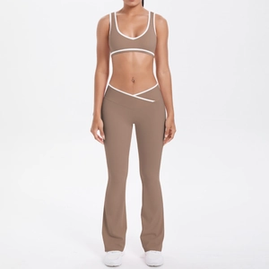Detail of high-waist flared yoga pants with crossover waistband and white contrast piping