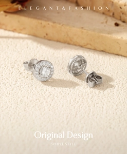 Detailed close-up of S925 sterling silver moissanite halo stud earrings on textured surface