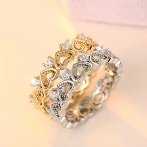 Macro shot of gold and silver heart crown rings with sparkling cubic zirconia stones